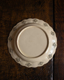 White ceramic plate with decorative edge on a wooden surface