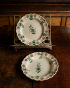 Two decorative plates with green floral patterns on a wooden surface.