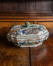 Decorative ceramic tureen with floral patterns on a wooden surface