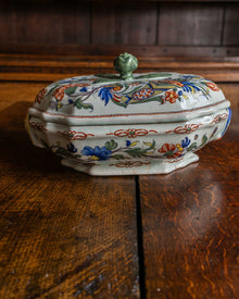 Decorative ceramic tureen with floral patterns on a wooden surface