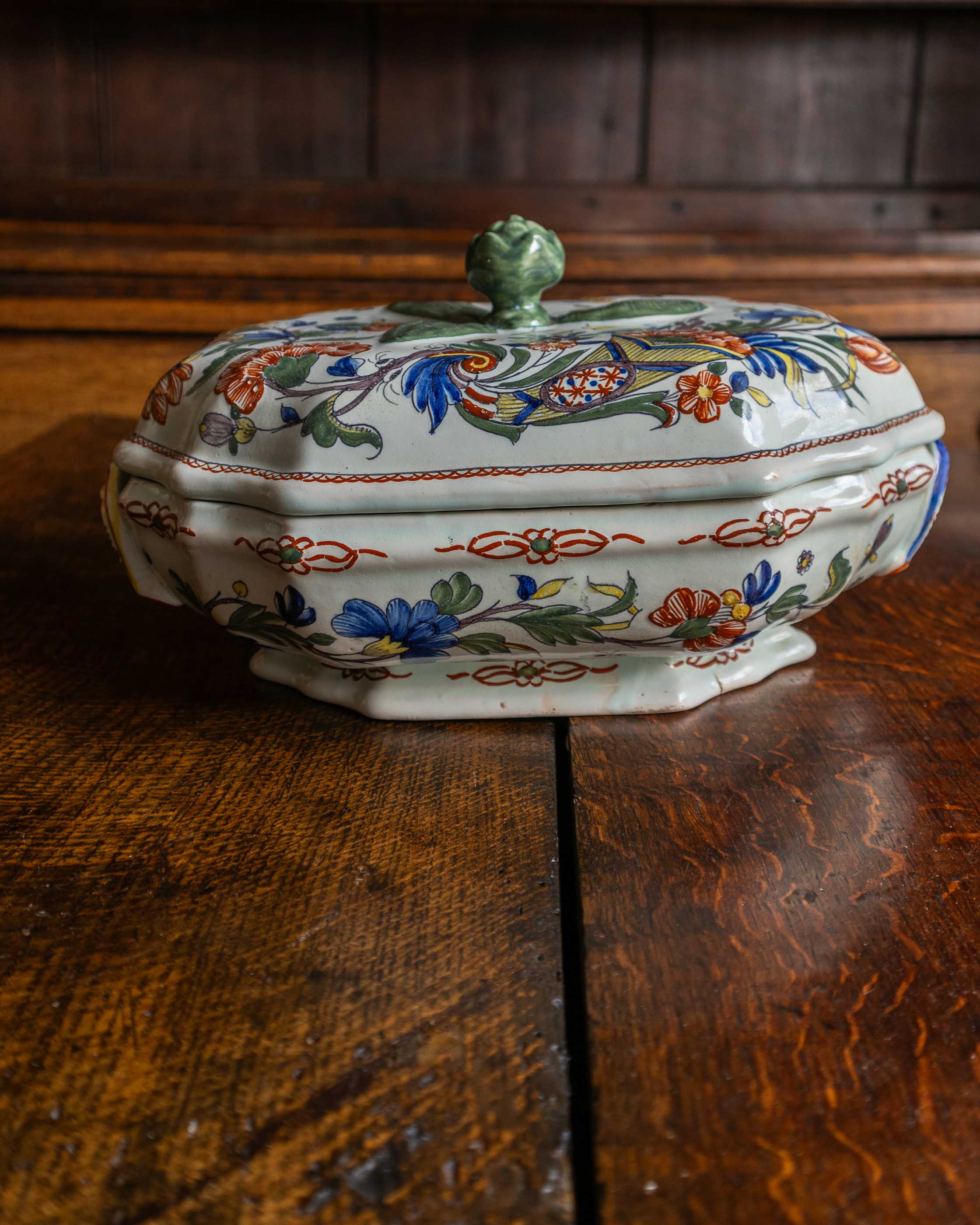 Decorative ceramic tureen with floral patterns on a wooden surface