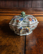 Decorative ceramic tureen with floral patterns on a wooden surface
