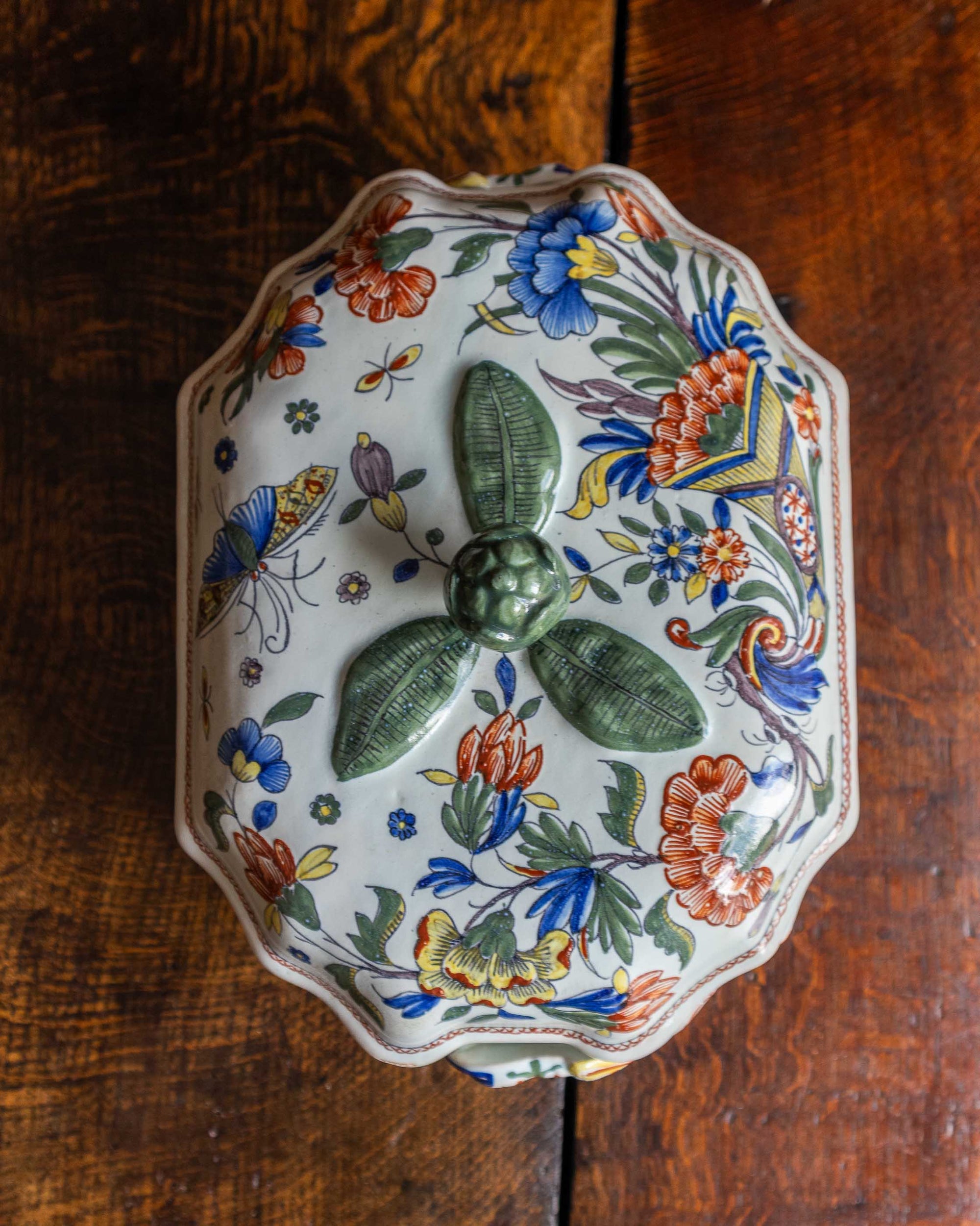 Decorative ceramic tureen with floral patterns on a wooden surface