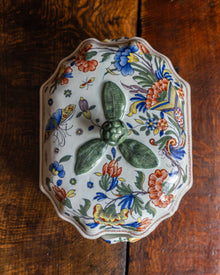 Decorative ceramic tureen with floral patterns on a wooden surface