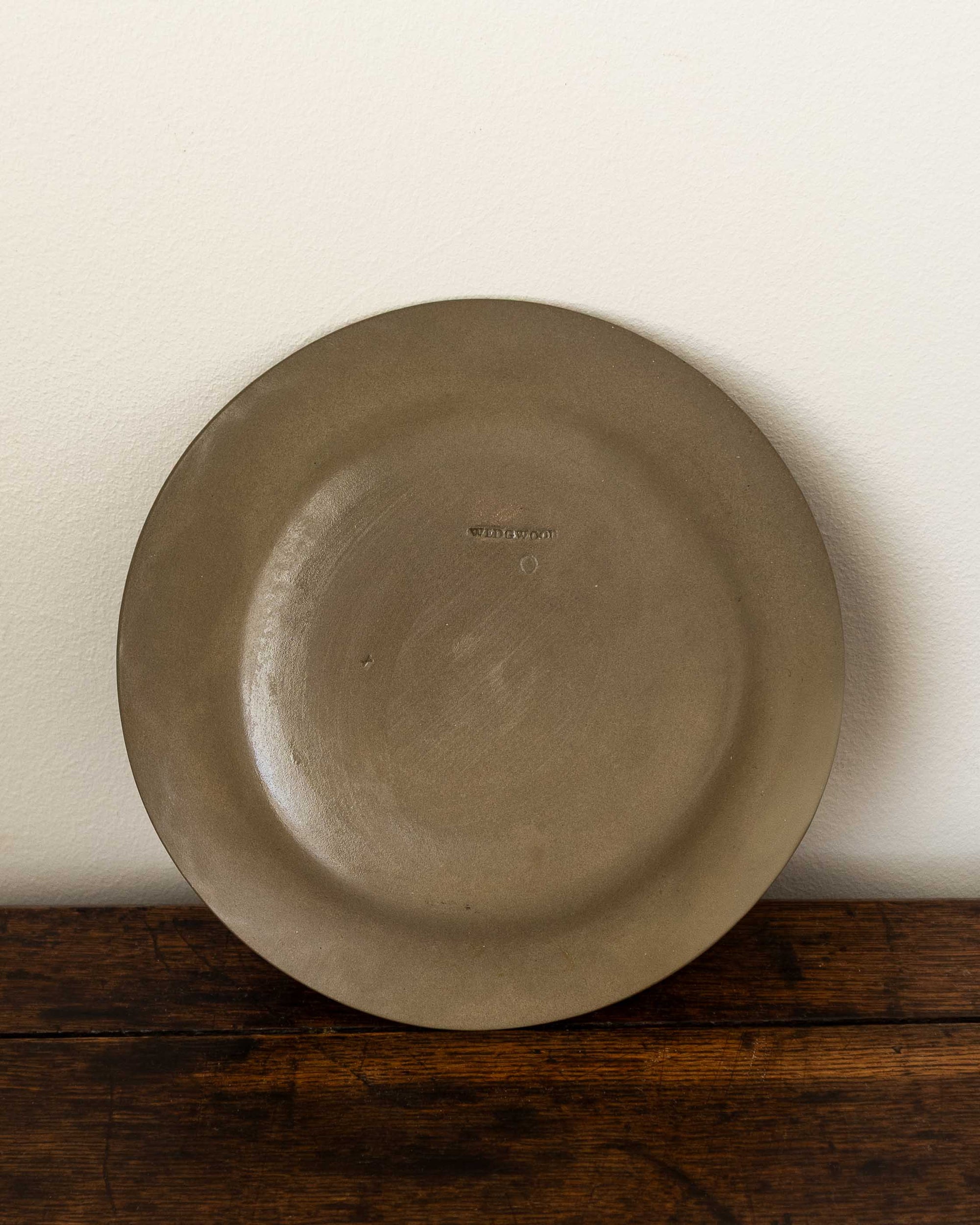 Brown ceramic plate on a wooden surface with a white background