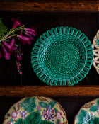 Green green woven plate on a wooden surface with floral decorations in the background