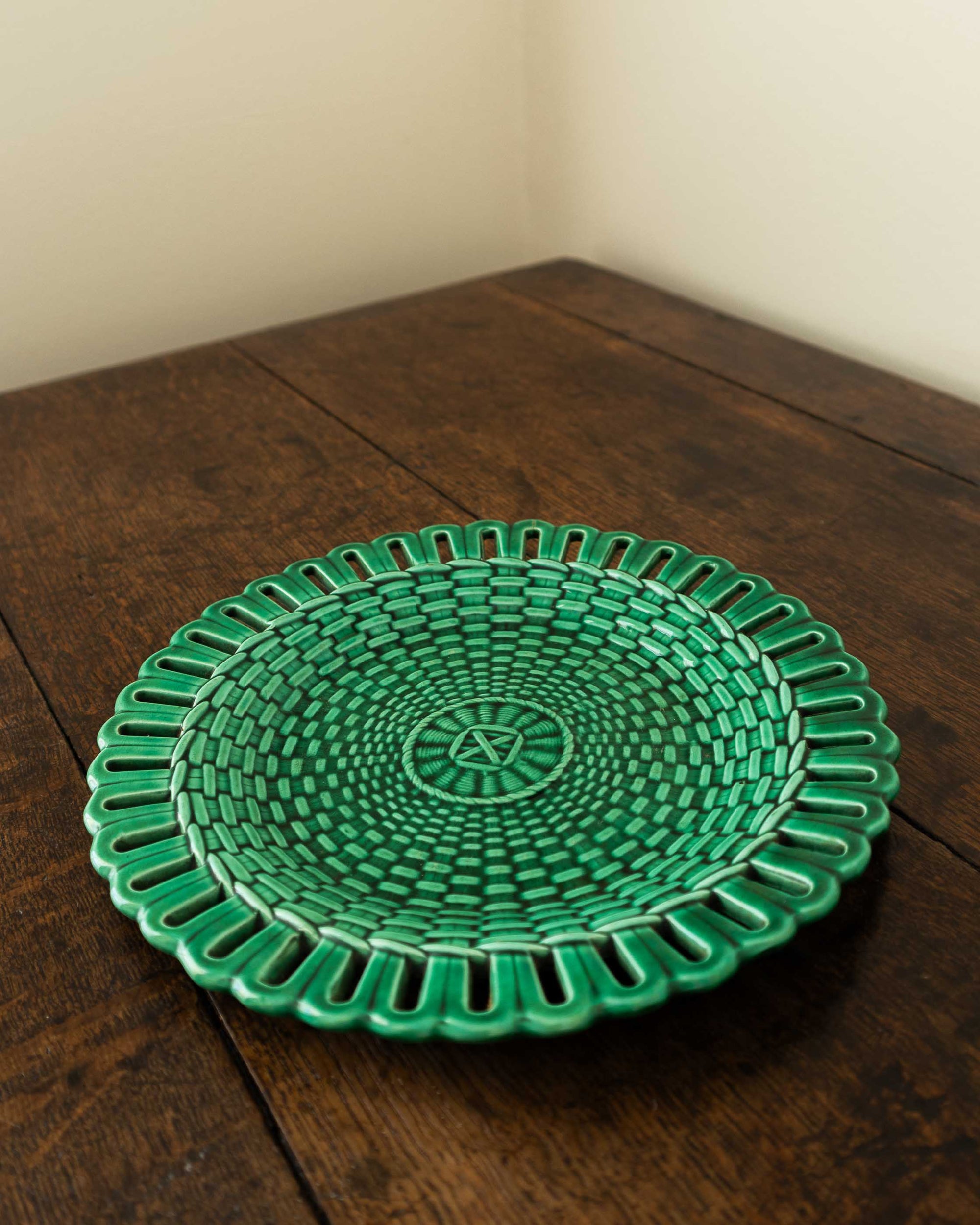 Green woven plate on a wooden surface