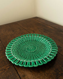 Green woven plate on a wooden surface