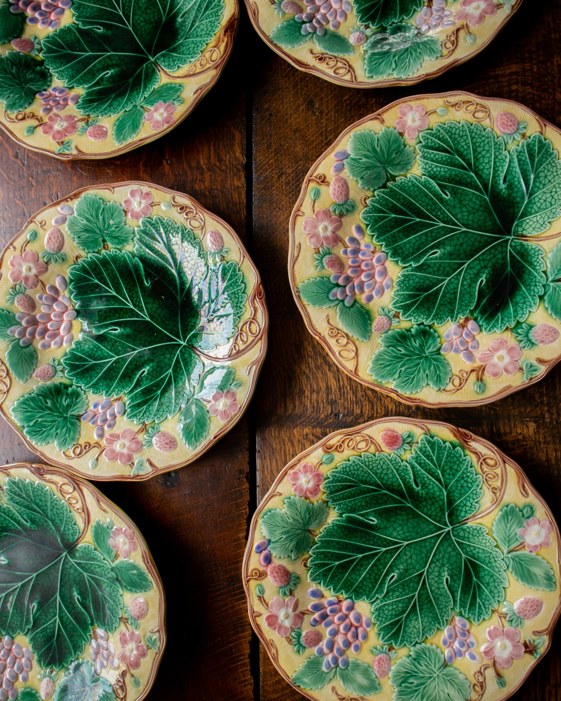 Decorative ceramic plates with leaf and floral patterns on a wooden surface