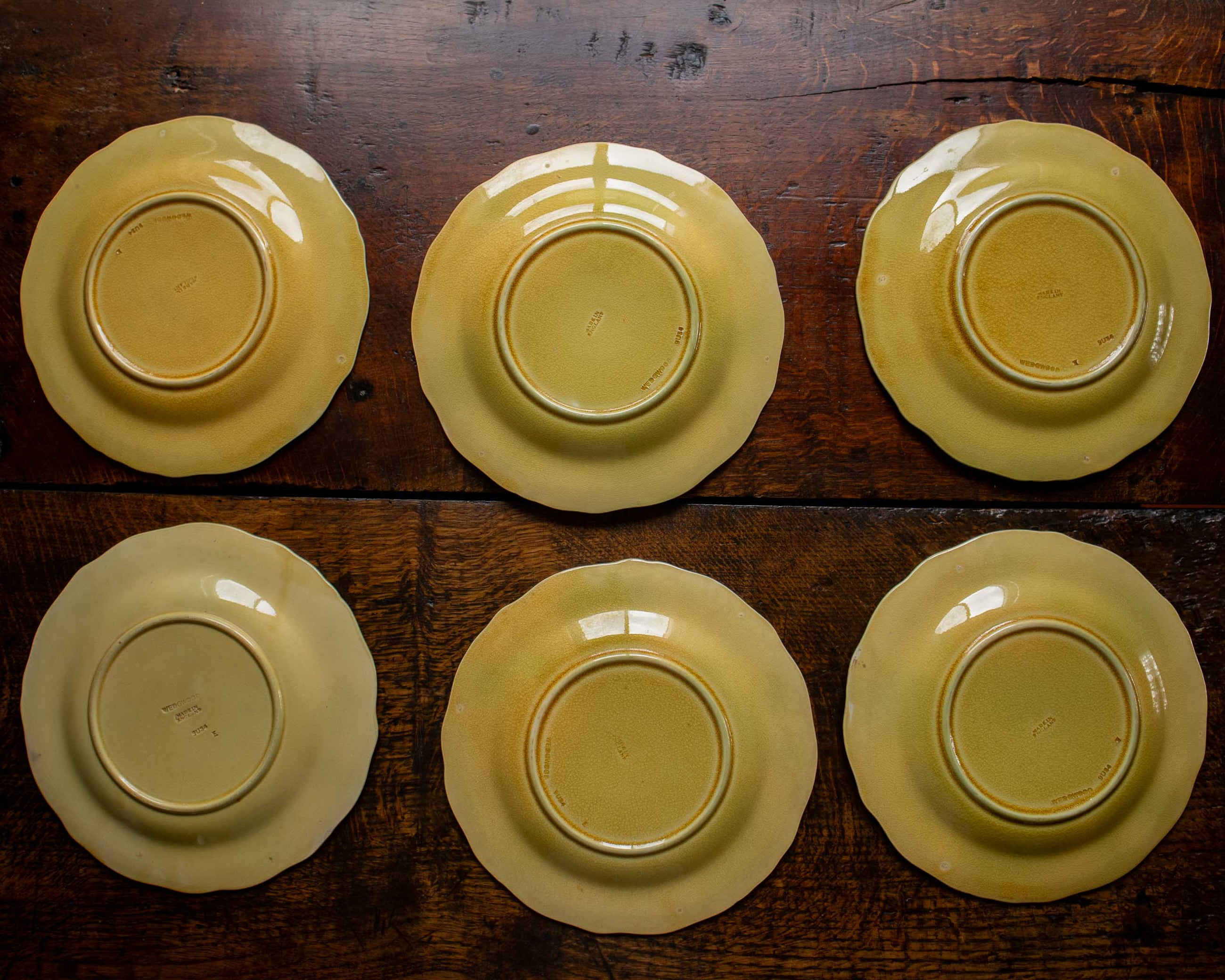 Six yellow ceramic plates on a wooden surface