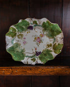 Decorative plate with floral and leaf design on a wooden surface