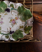 Decorative plate with floral and leaf patterns on a wooden surface