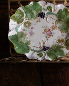 Decorative ceramic plate with floral and leaf patterns on a wooden surface