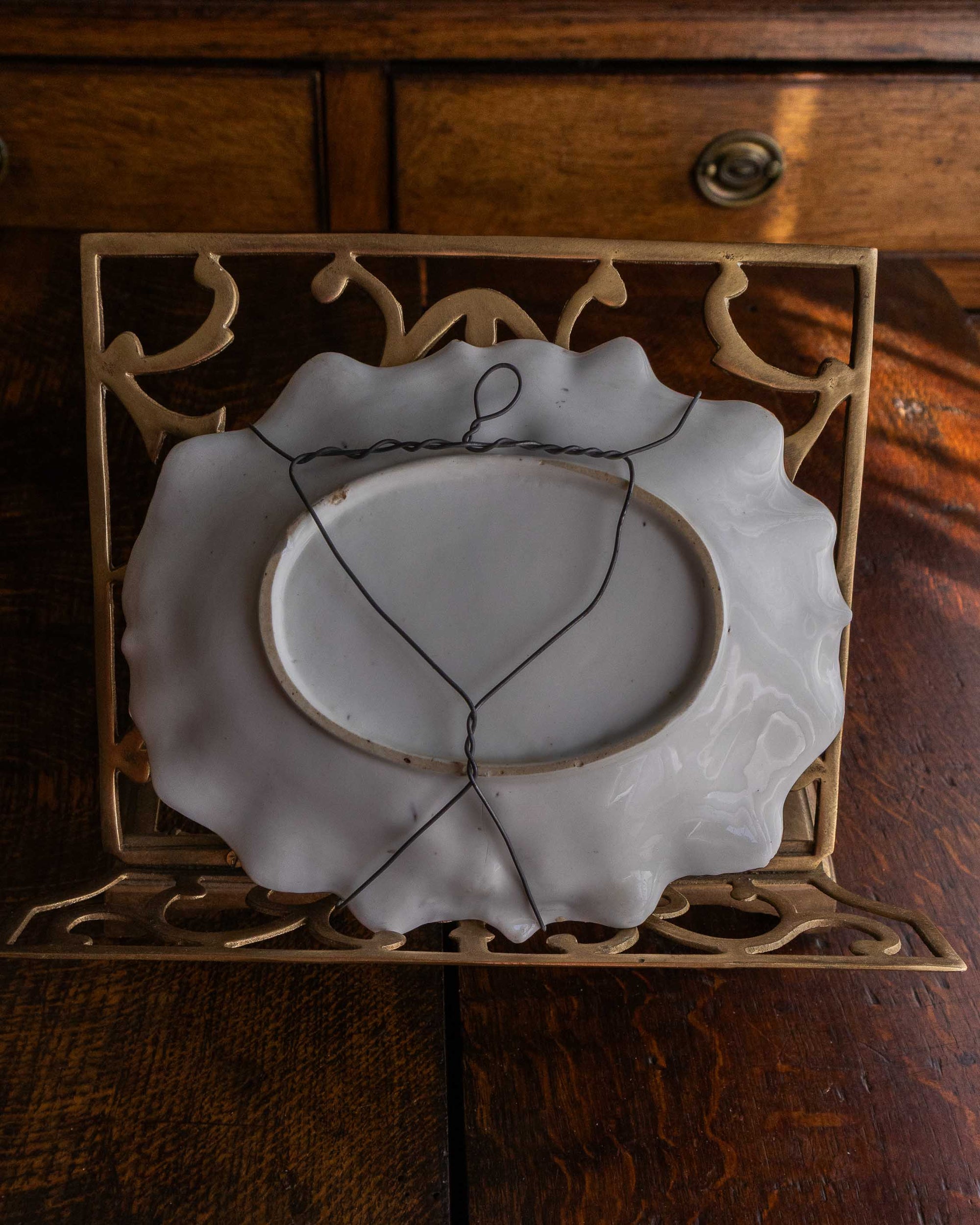 Decorative white plate with a decorative stand on a wooden surface
