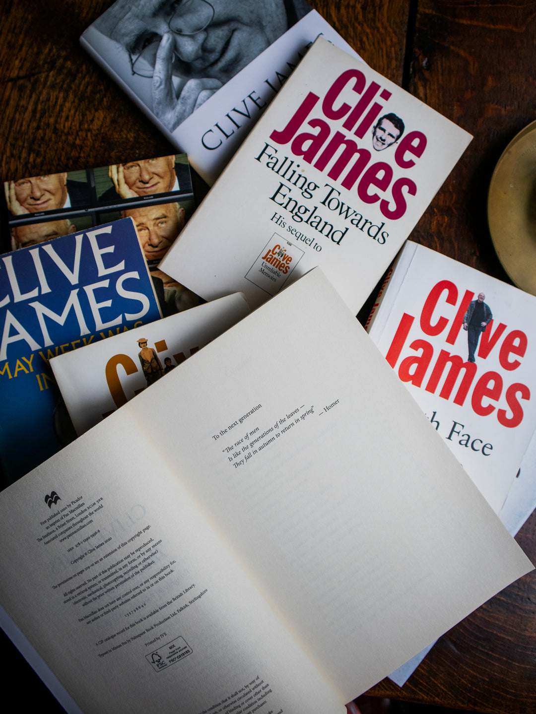 Collection of Clive James books on a wooden surface