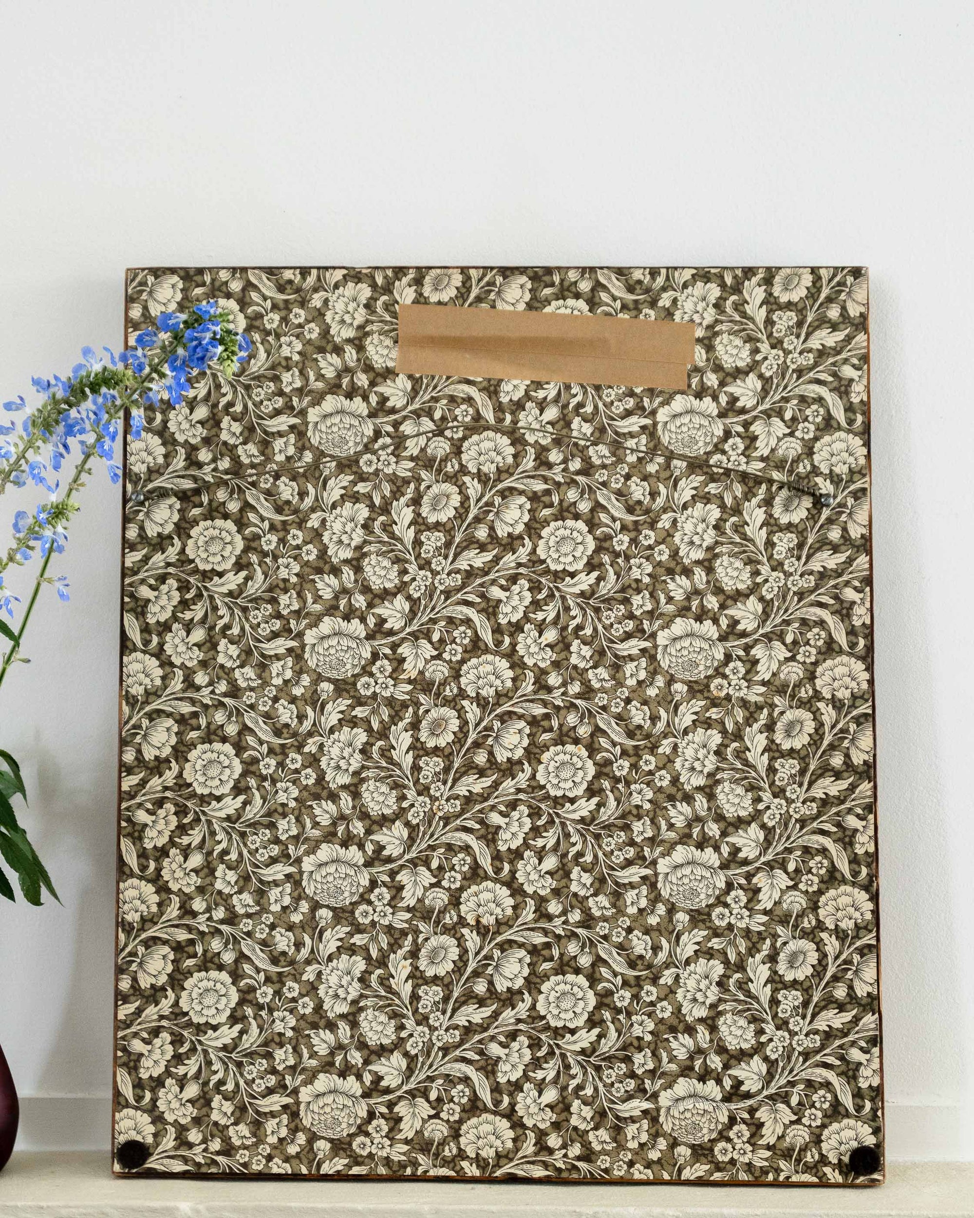 Floral patterned sampler with a brown label on a white background