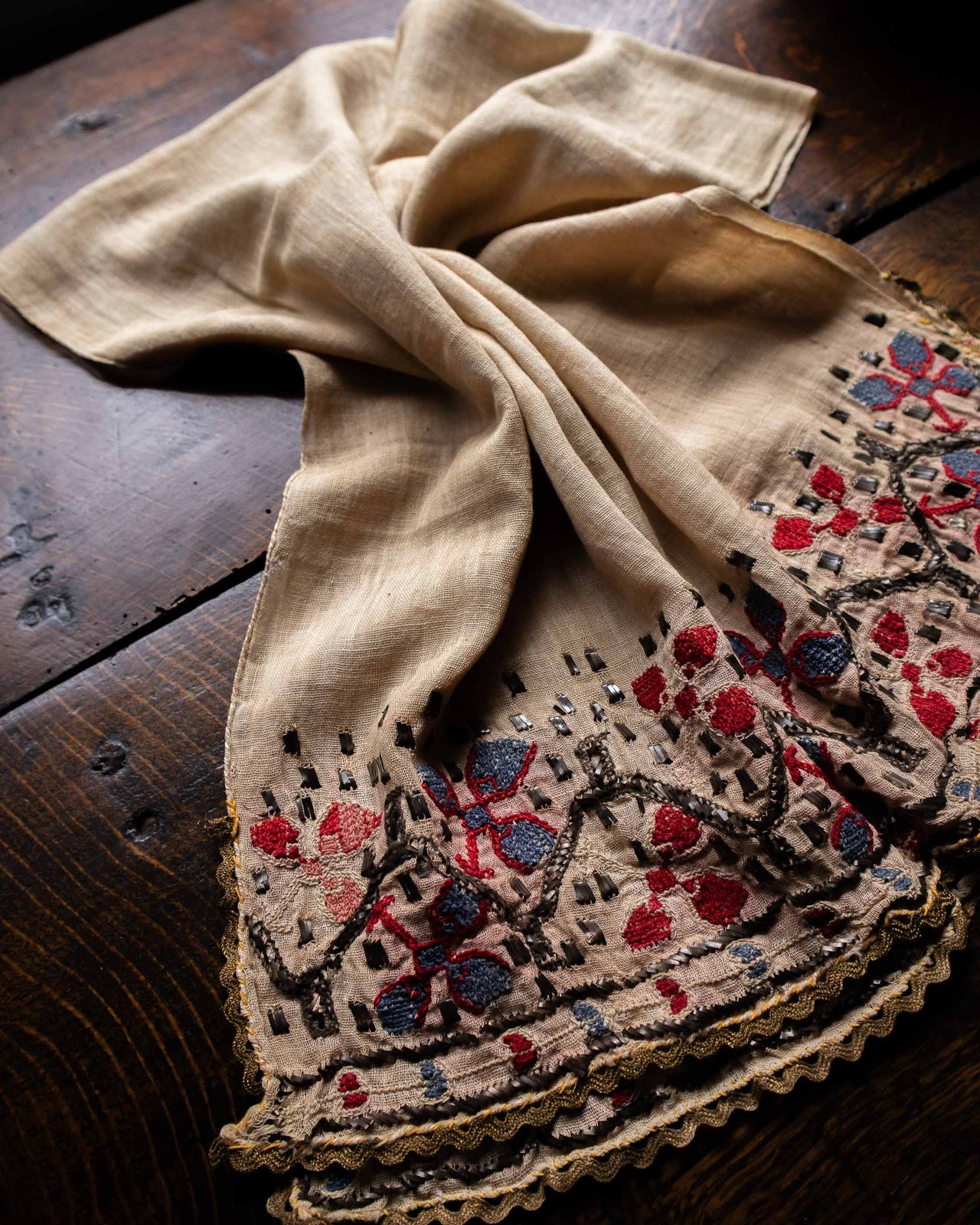 Embroidered fabric with floral patterns on a wooden surface