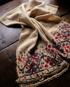 Embroidered fabric with floral patterns on a wooden surface