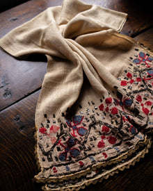 Embroidered fabric with floral patterns on a wooden surface