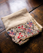 Embroidered fabric with floral patterns on a wooden surface