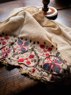 Embroidered fabric with floral patterns on a wooden surface