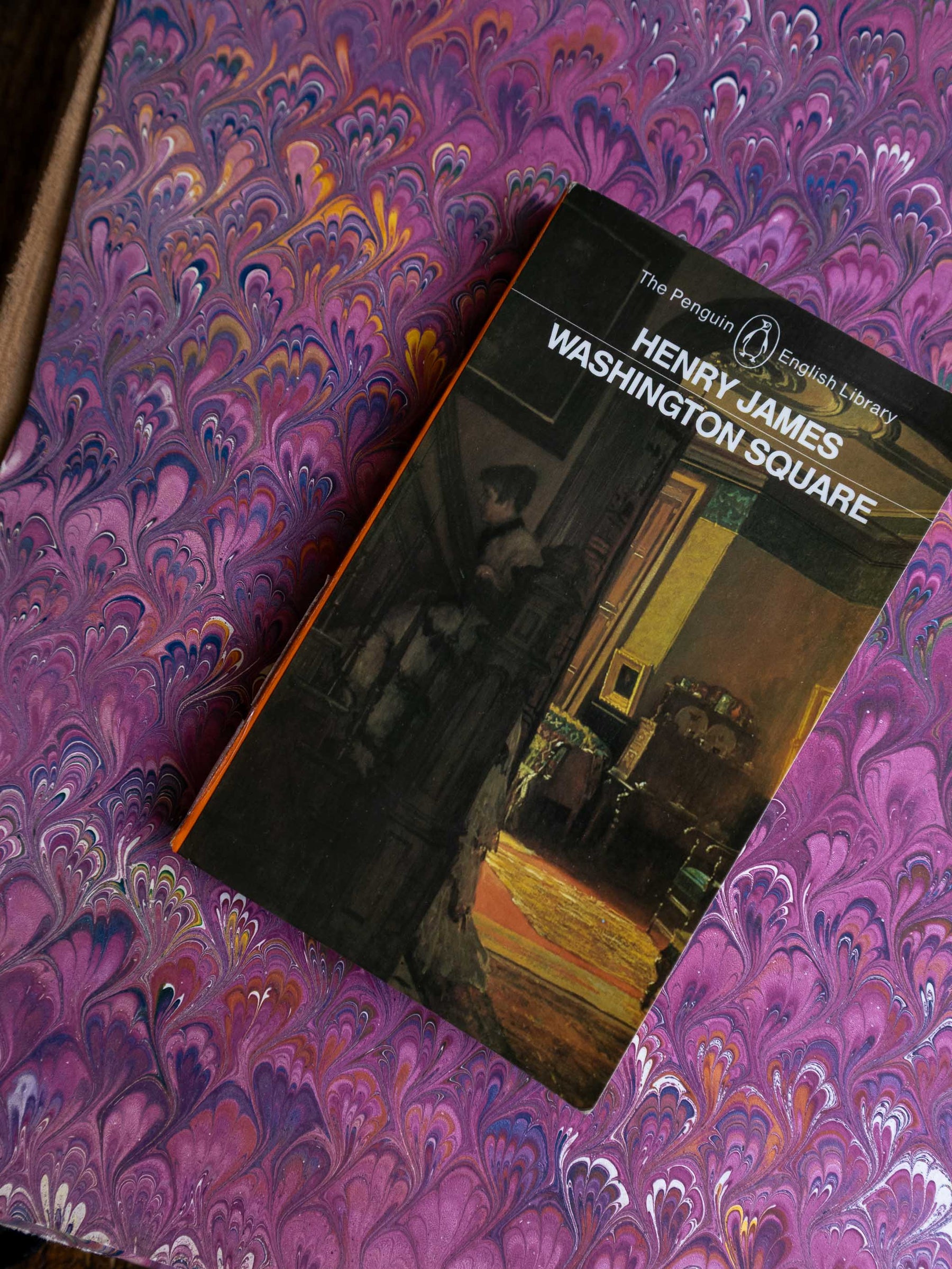 Book titled 'Washington Square' by Henry James on a purple marbled background