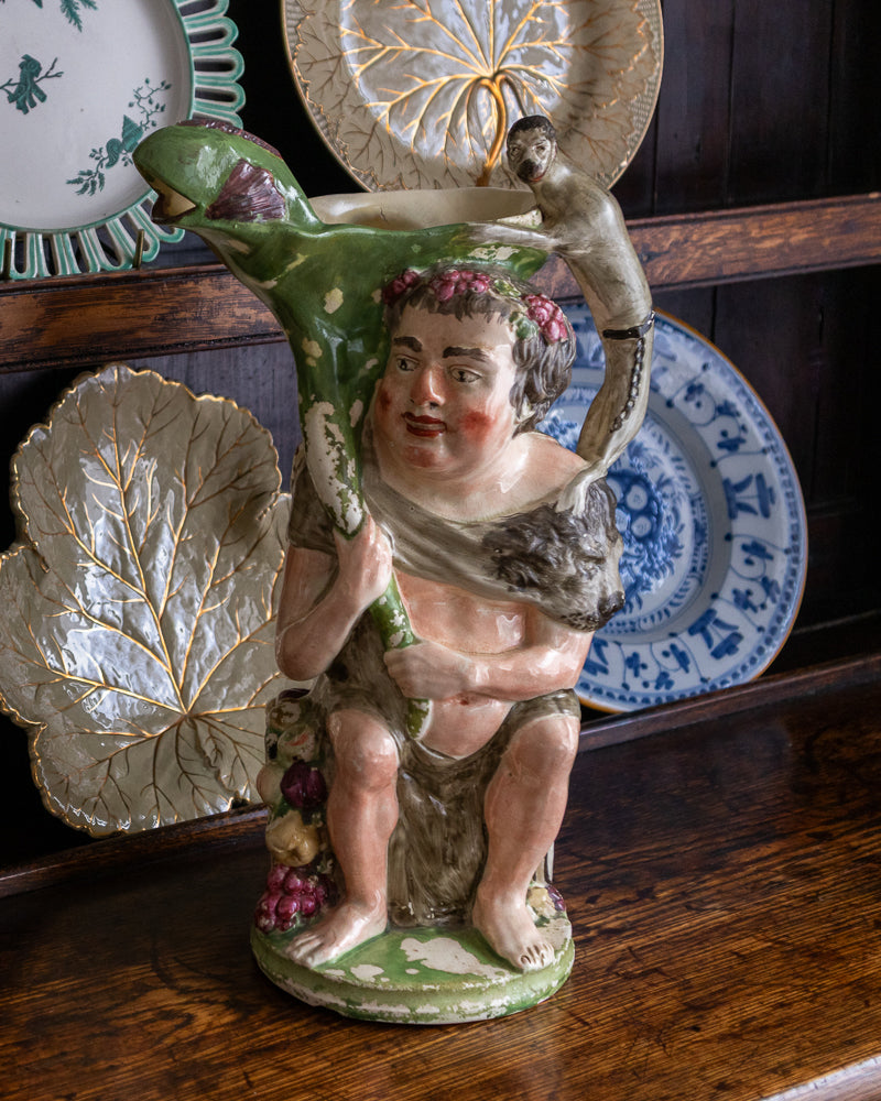 Decorative ceramic figure of a classical youth with a bird on a wooden surface with decorative plates in the background.