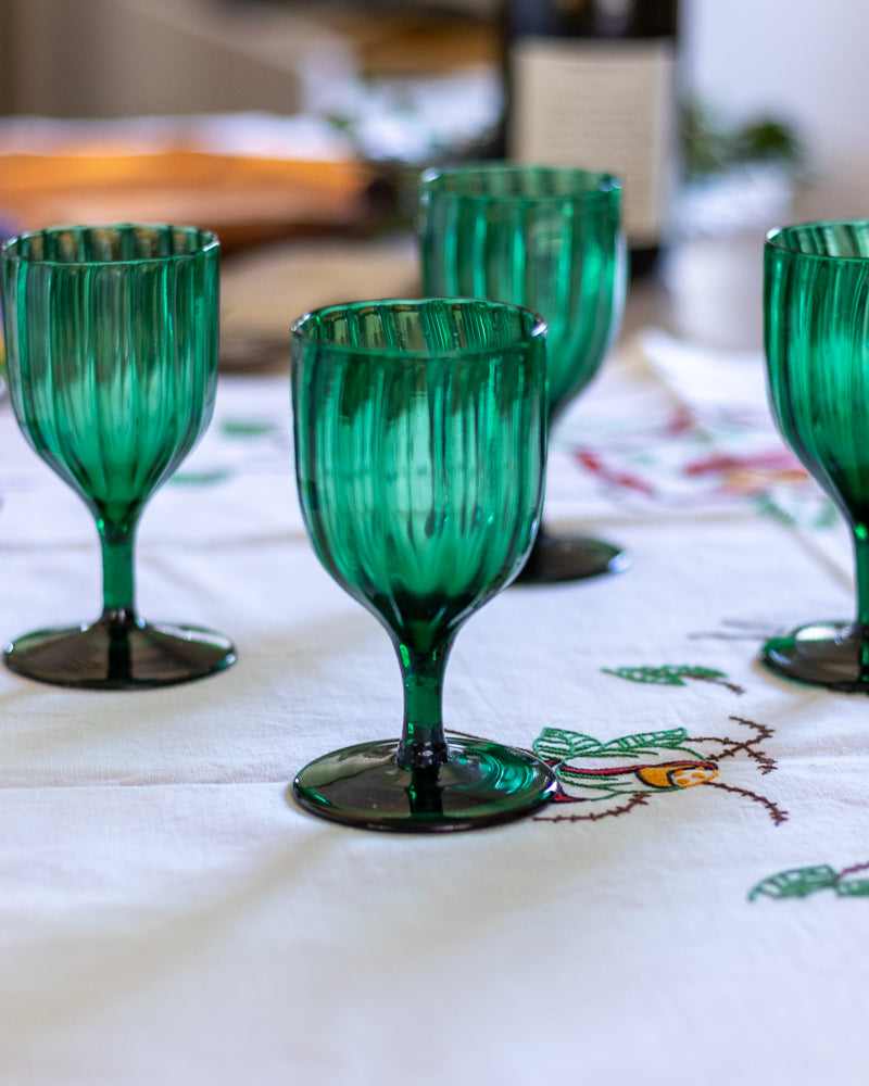 Green glass goblets on a patterned tablecloth