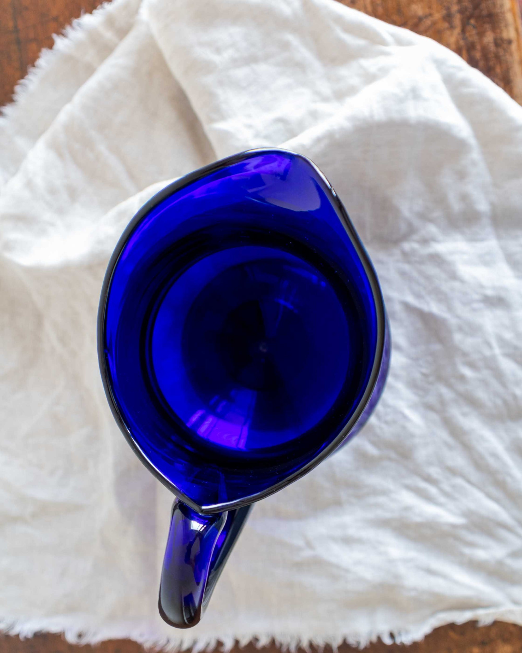 Blue glass pitcher on a white cloth