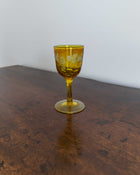 Yellow glass with floral design on a wooden surface