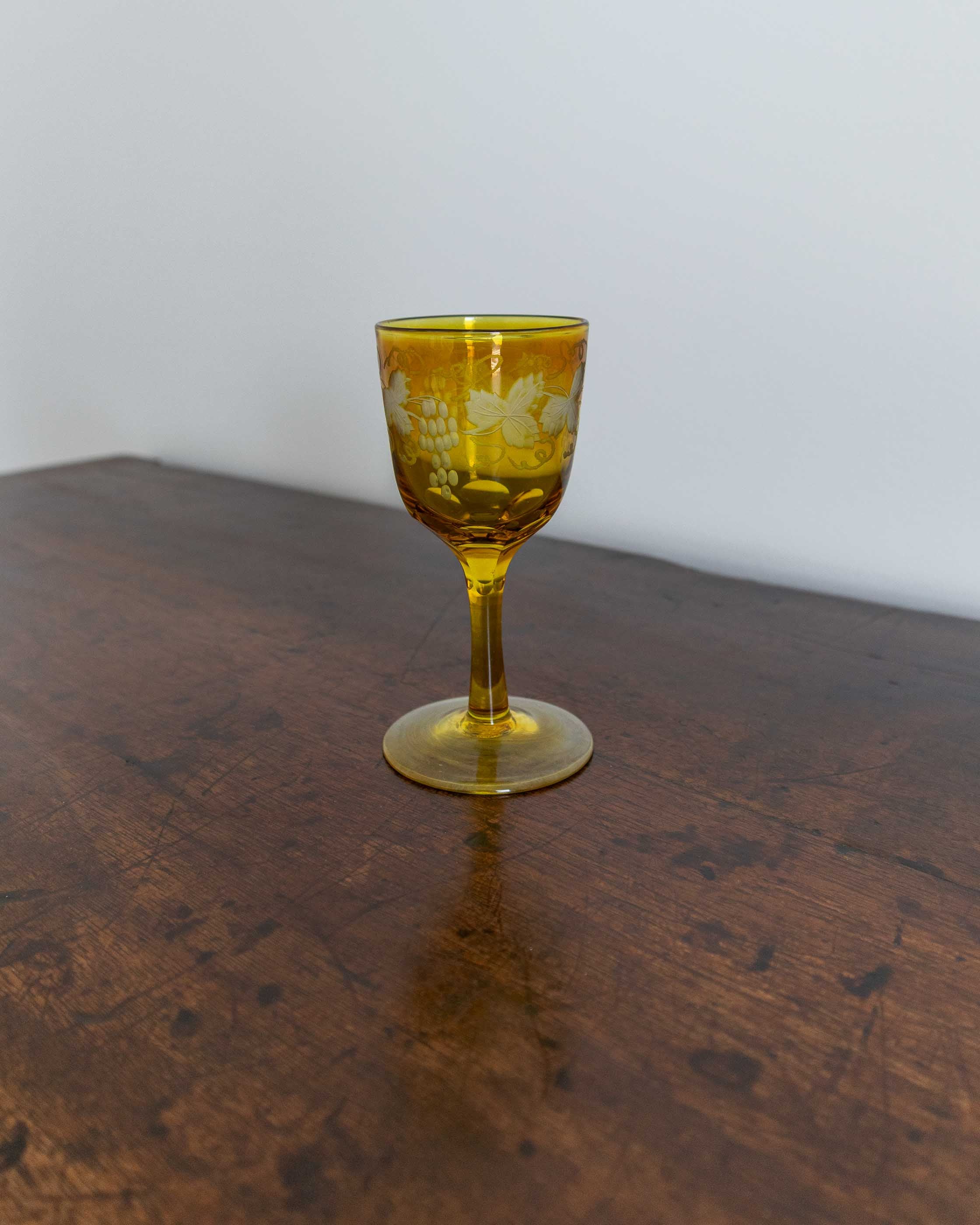 Yellow glass with floral design on a wooden surface