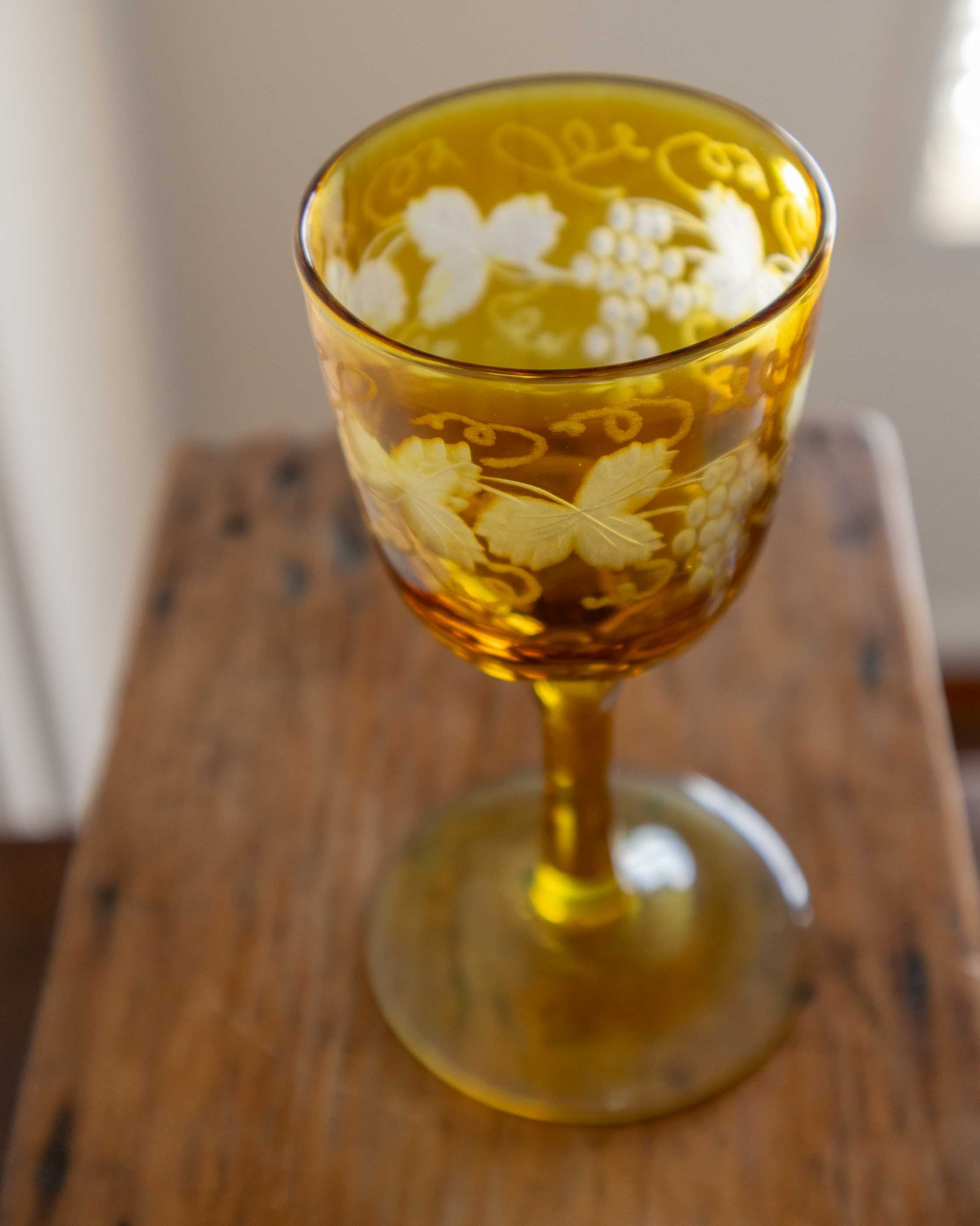 Decorative amber glass with floral patterns on a wooden surface
