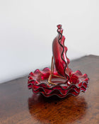Red glass bowls on a wooden surface with a white background