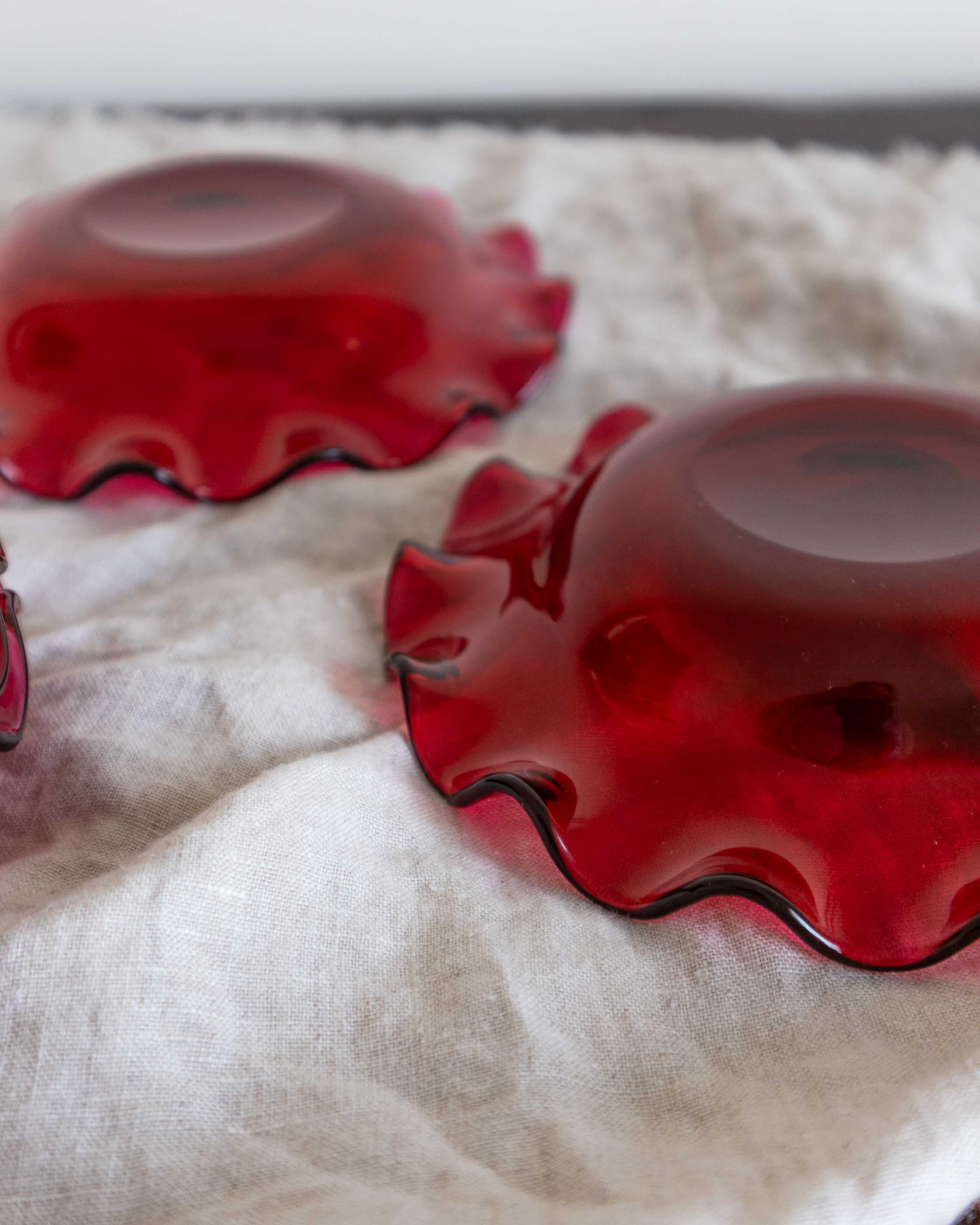 Red glass bowls on a white cloth