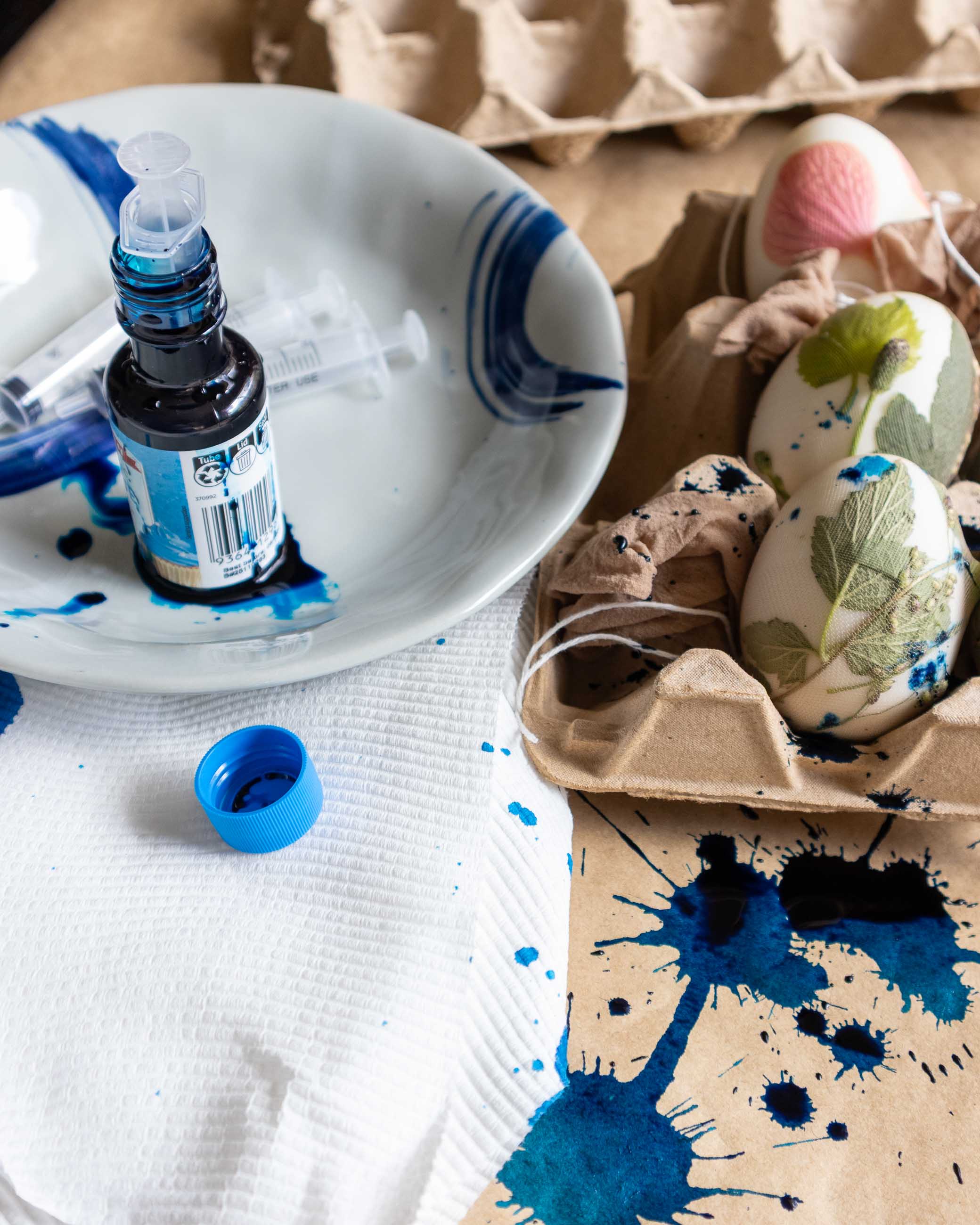 Easter egg decorating with blue paint and egg carton on a table