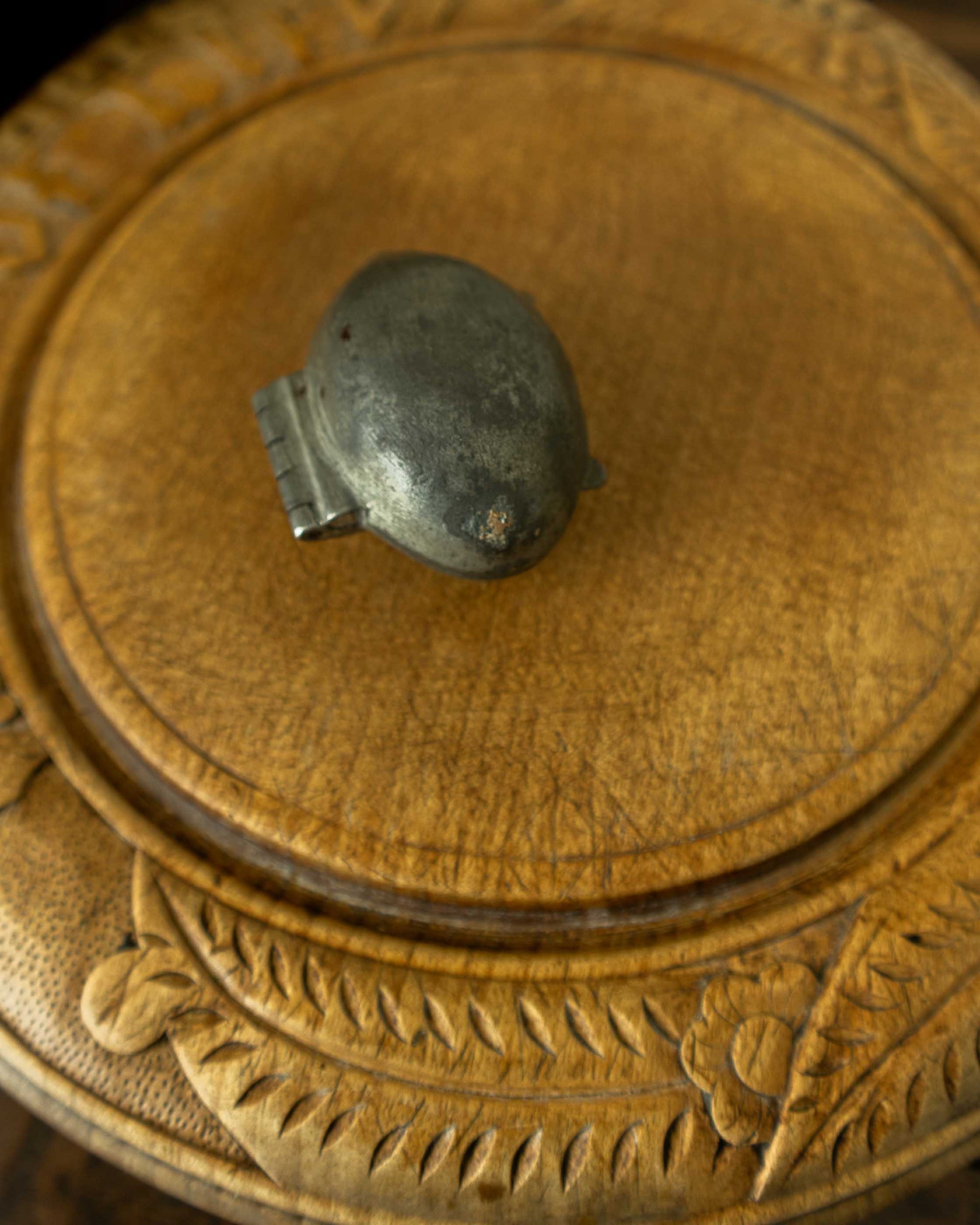 Lemon pewter ice cream mould on wooden breadboard with a dark background