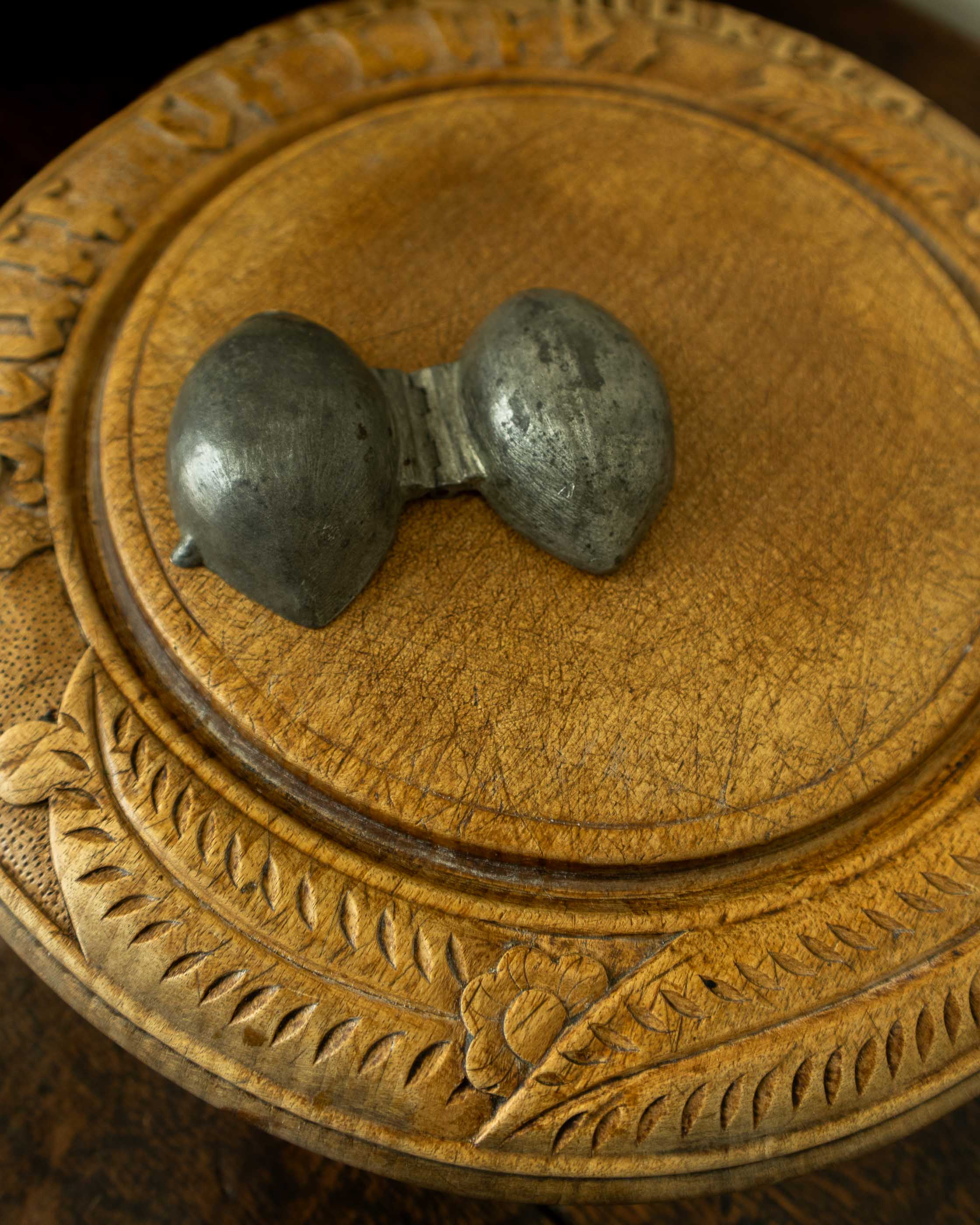 Lemon pewter ice cream mould on wooden breadboard with a dark background