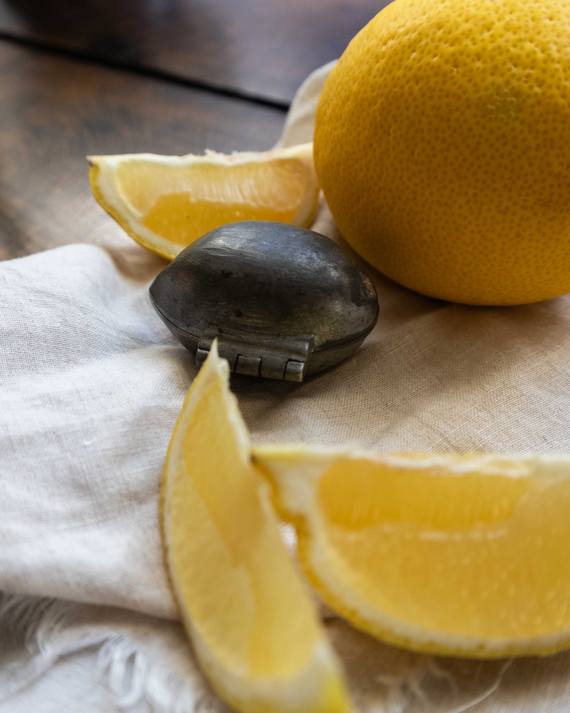 Lemon pewter ice cream mould on wooden with lemons on a white cloth