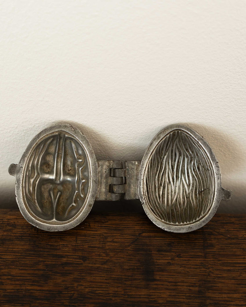 Walnut pewter ice cream mould on wooden surface