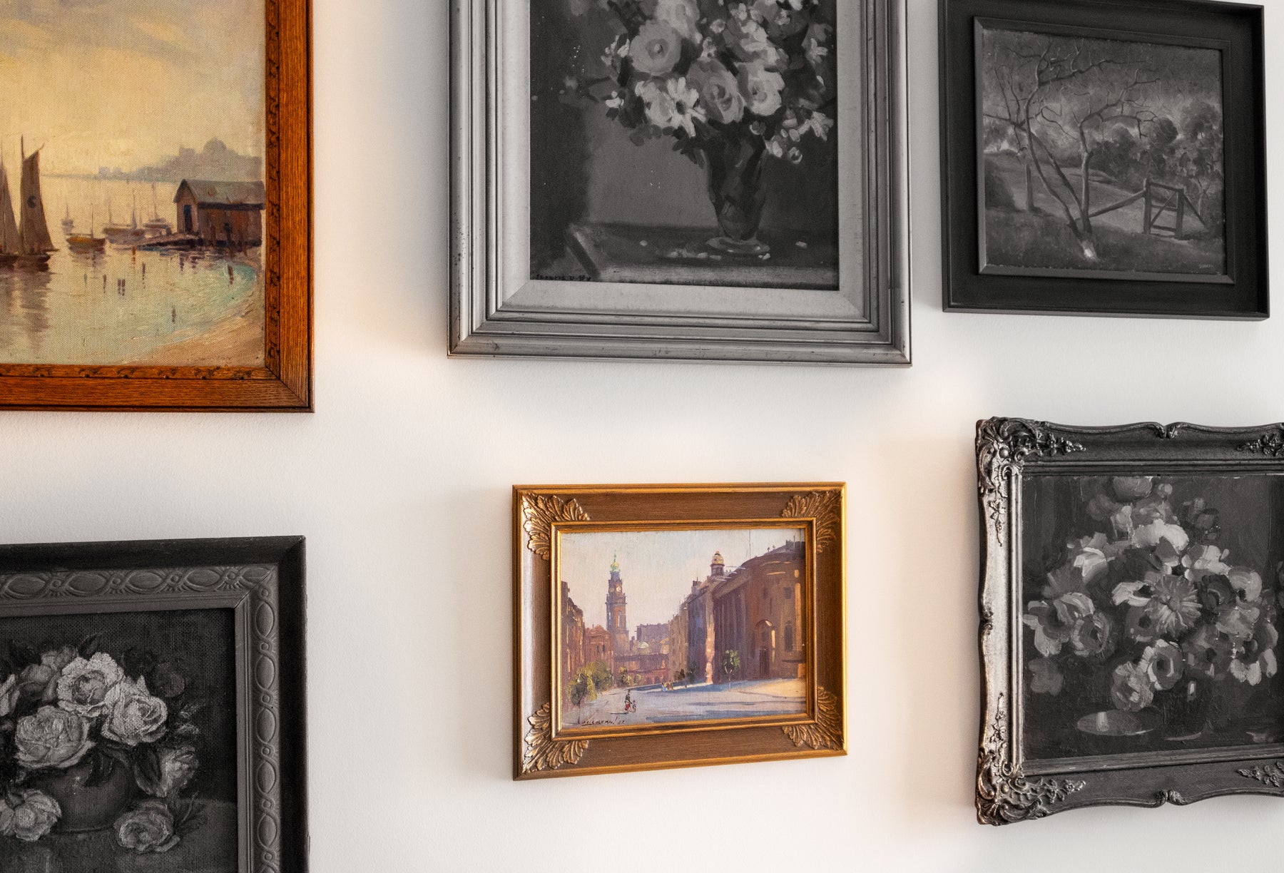 Collection of framed paintings on a wall