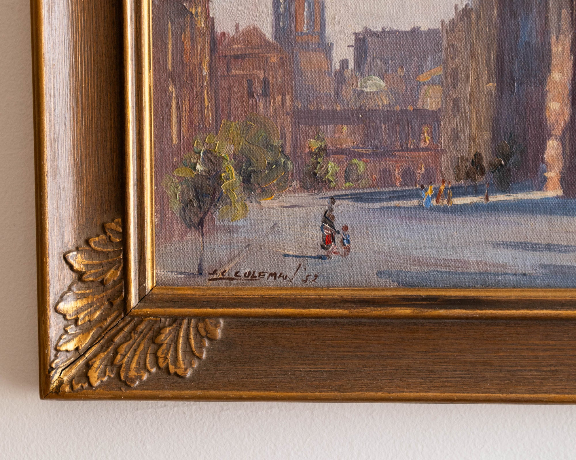 Framed painting of a city street scene with people and buildings.