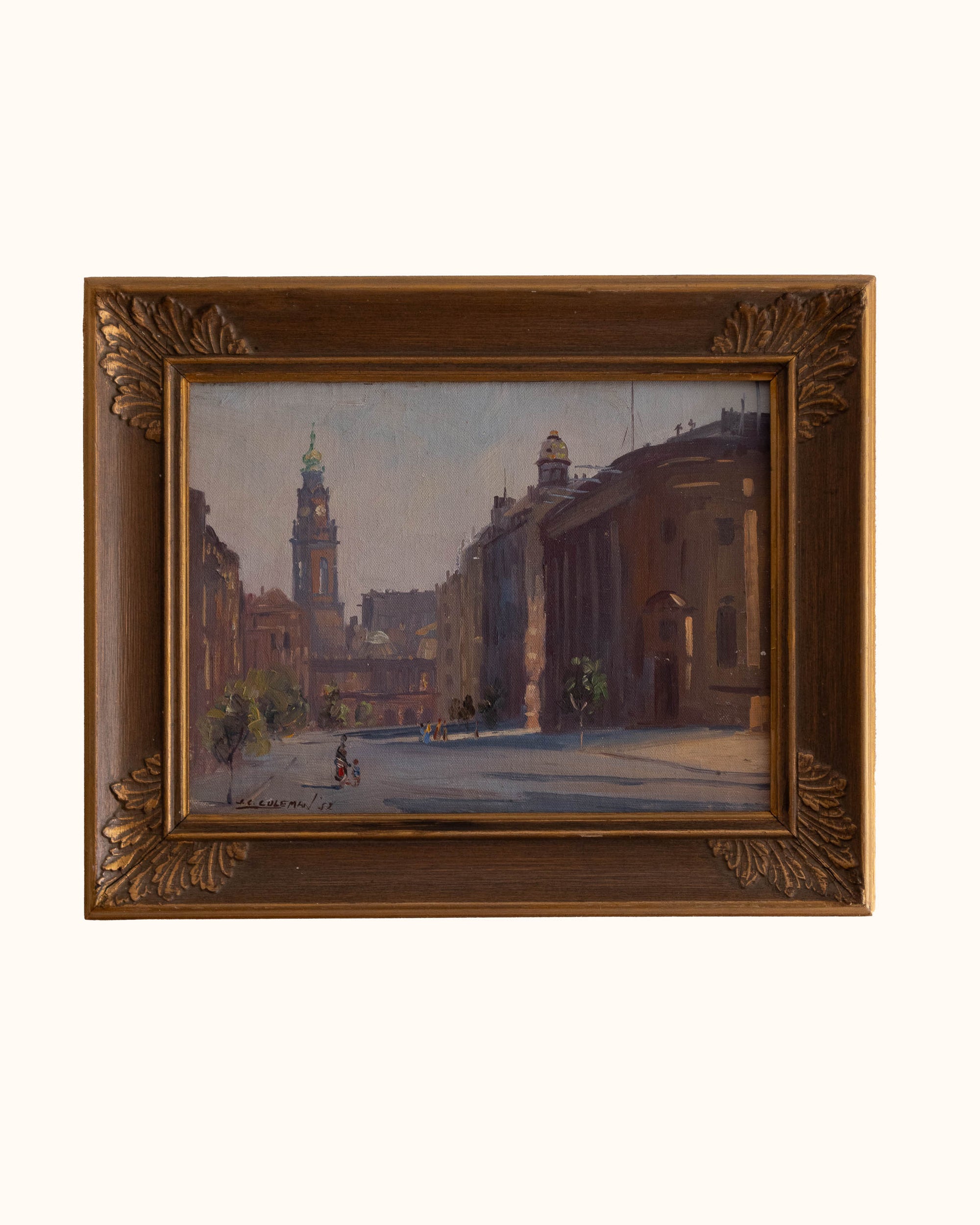 Framed painting of a city street scene with ornate gold frame
