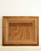 Wooden picture frame with a signature on a white background