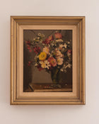 Framed painting of a still life with flowers on a beige wall