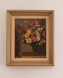 Framed painting of a still life with flowers on a beige wall