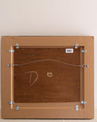 Back of a wooden frame with metal brackets and numbers on a beige background