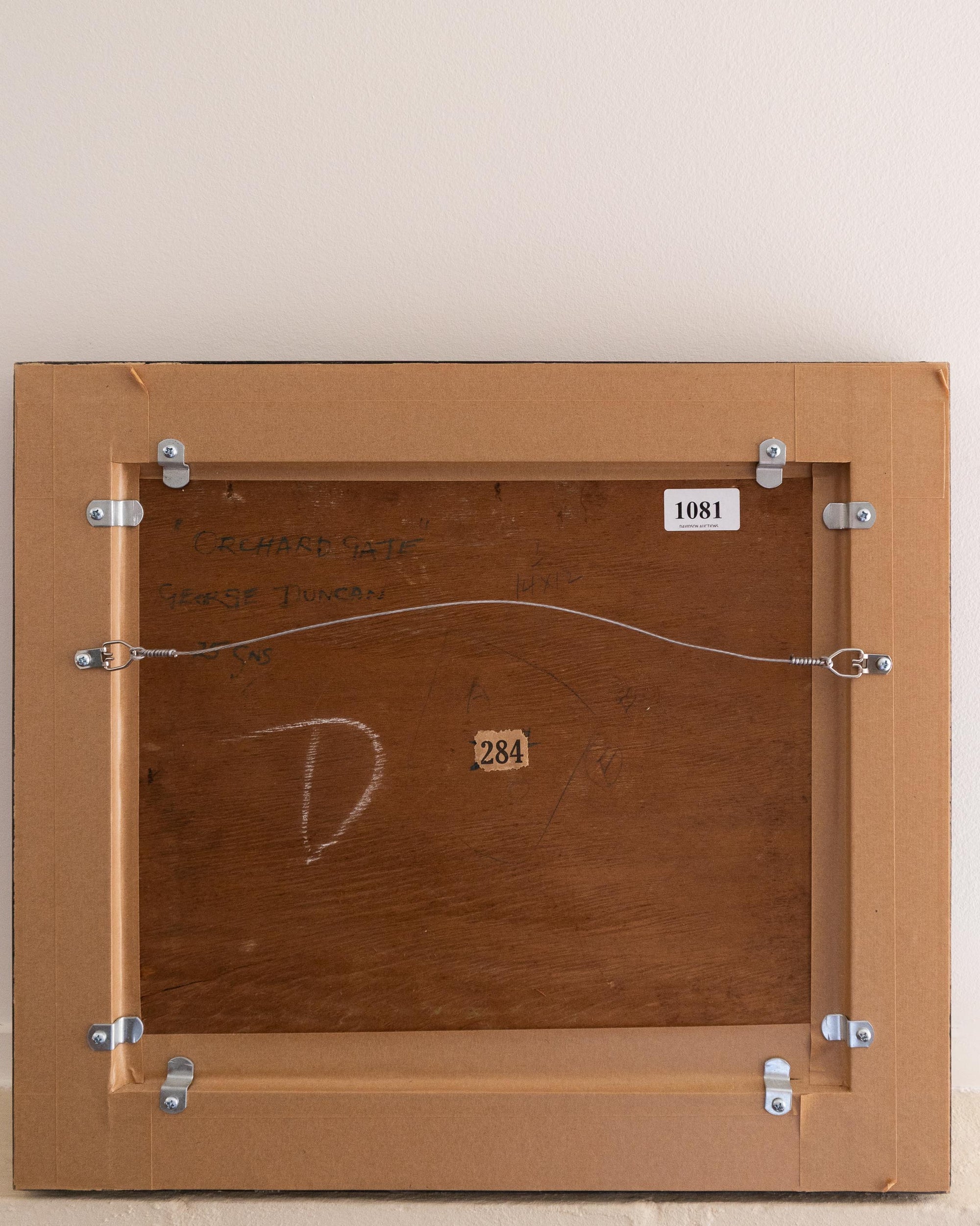 Back of a wooden frame with metal brackets and numbers on a beige background