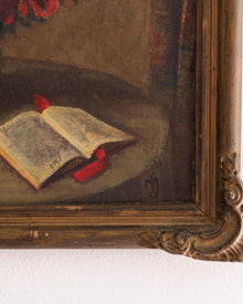 Still life painting with an open book and red objects, framed in ornate wood.