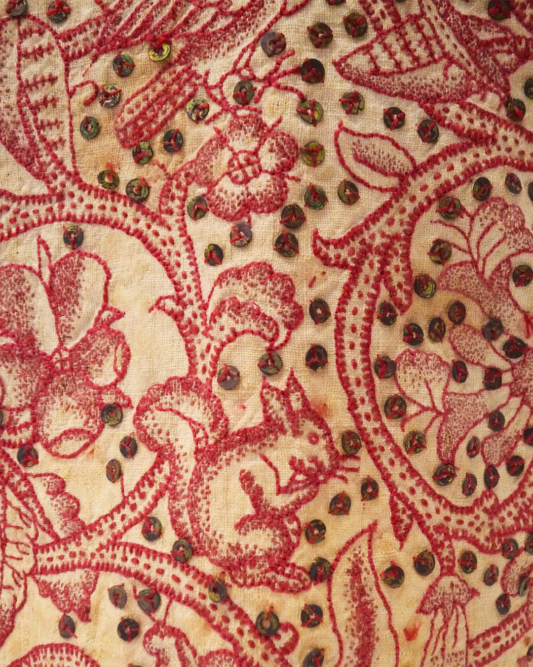 Close-up of a fabric with intricate red and beige paisley pattern