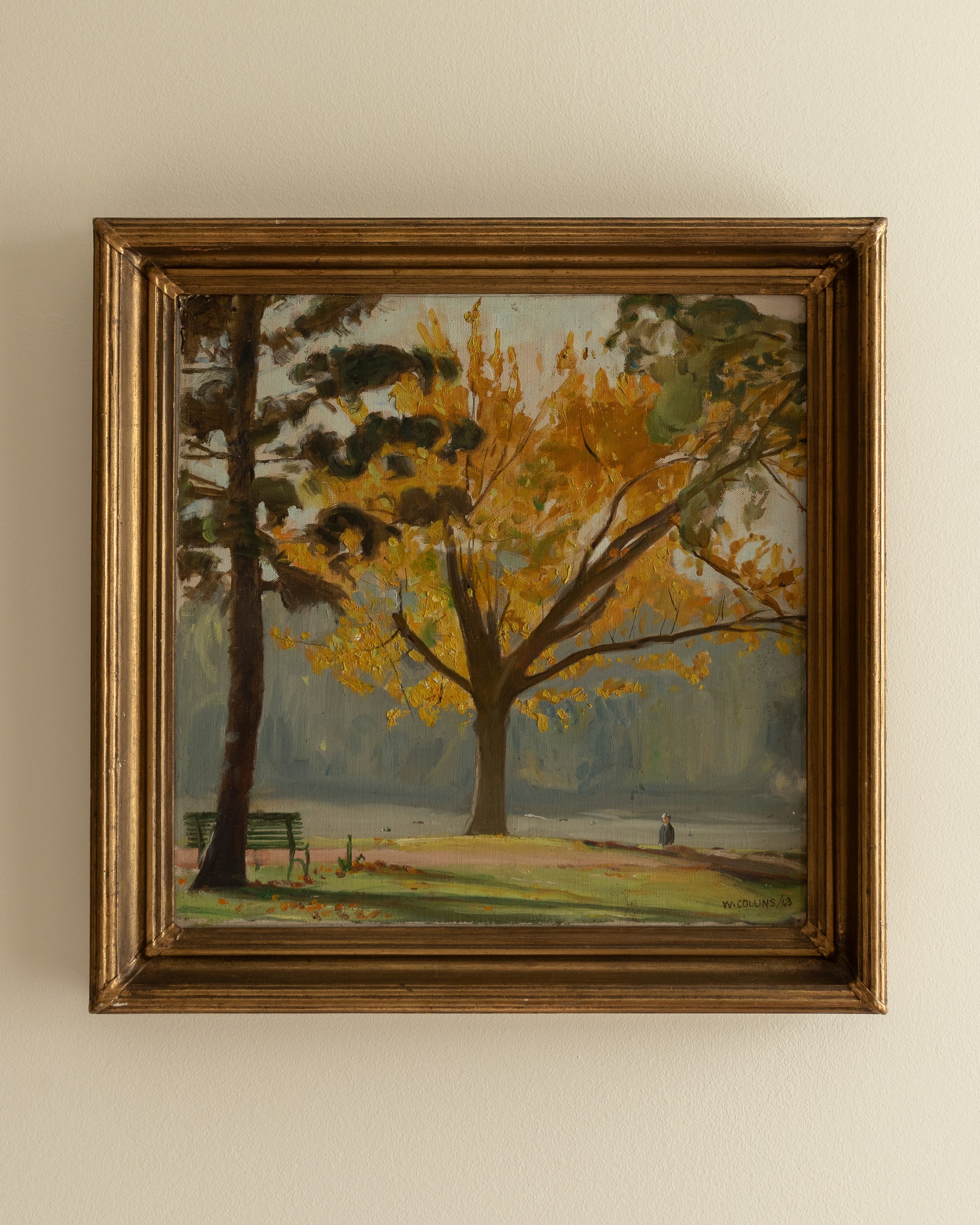 Framed painting of a tree with yellow leaves on a beige wall